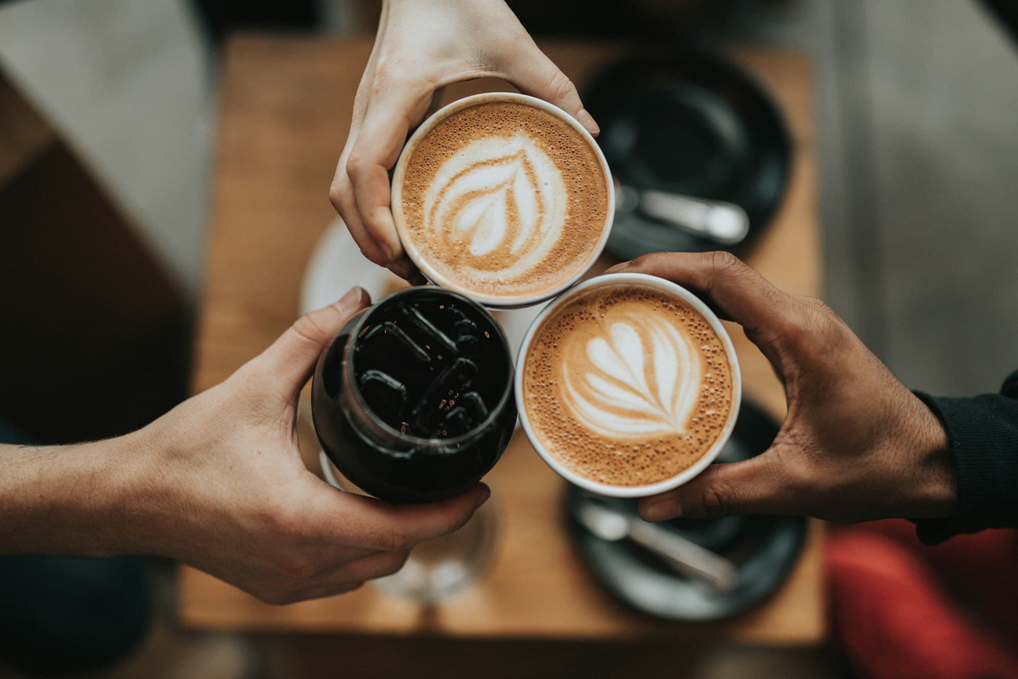 Tách cà phê latte và hạt cà phê rang trên nền tối
